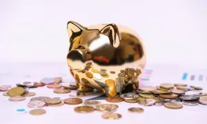 Złota skarbonka otoczona monetami. Zastanawiasz się, kiedy sąd może żądać wyciągu z konta?
