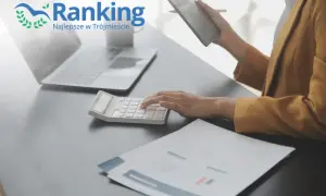 Ręce na kalkulatorze, laptop i tablet na biurku, logo "Ranking Najlepsze w Trójmieście".