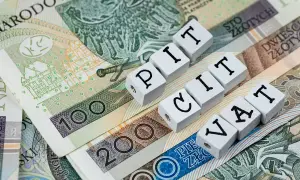 Polskie banknoty z napisami PIT i VAT. Ulga na złe długi może pomóc w rozliczeniu podatków.