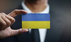Dłoń trzyma kartkę z flagą Ukrainy. Sytuacja jest taka, jaka jest, ale nadzieja pozostaje.
