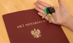 Akt notarialny i klucze w dłoni. Komparycja dokumentów i symbolu własności.