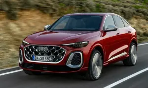 Czerwony Audi Q8 Sportback sunie po drodze, idealny do leasingu finansowego.