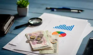 Analiza finansowa, pieniądze, lupa i wykresy na biurku. Planowanie restrukturyzacji kredytu.