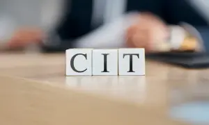 Trzy kostki z literami C, I, T. Symbolizują podatek CIT, który jest ważnym elementem finansów firm.