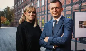 Dwoje prawników w garniturach przed ceglanym budynkiem.
