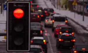 Czerwone światło sygnalizatora, stojące samochody w korku. Uważaj, bo za przejazd na czerwonym grozi mandat.