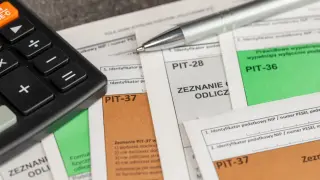 Kalkulator i długopis na dokumentach PIT. Przygotowanie zeznania podatkowego, by uzyskać ulga na leki.