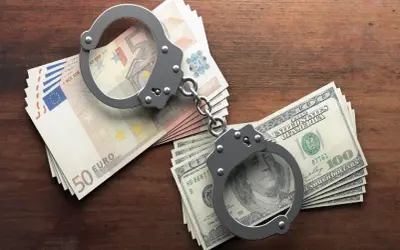 Kajdanki na stosach euro i dolarów. Historia o tym, jak pieniądze mogą prowadzić do kłopotów, zgodnie z art. 286 kk.