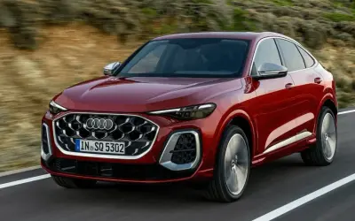 Czerwony Audi Q8 Sportback sunie po drodze, idealny do leasingu finansowego.