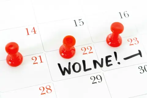 Kalendarz z zaznaczonymi dniami wolnymi. Czy to siła wyższa, ile dni wolnego? Czerwone pinezki oznaczają daty.