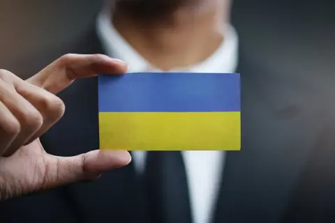 Dłoń trzyma kartkę z flagą Ukrainy. Sytuacja jest taka, jaka jest, ale nadzieja pozostaje.