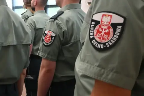 Na rękawach mundurów widnieje godło i napis "Służba Celno-Skarbowa".