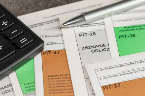 Kalkulator i długopis na dokumentach PIT-37, PIT-28, PIT-36. Zastanawiasz się, ile zwrotu z ulgi rehabilitacyjnej 2280? Czas na rozliczenie!