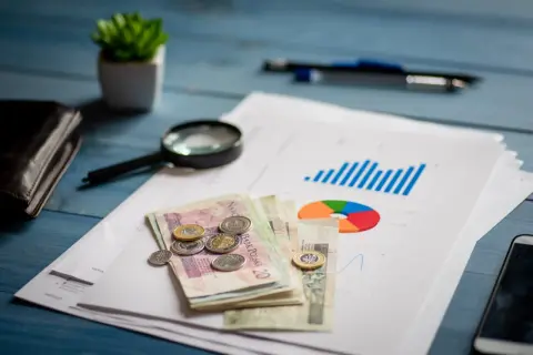 Analiza finansowa, pieniądze, lupa i wykresy na biurku. Planowanie restrukturyzacji kredytu.