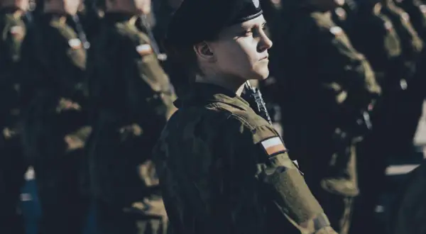 Kobieta w beretce i mundurze, gotowa do służby. To jej dobrowolna zasadnicza służba wojskowa.