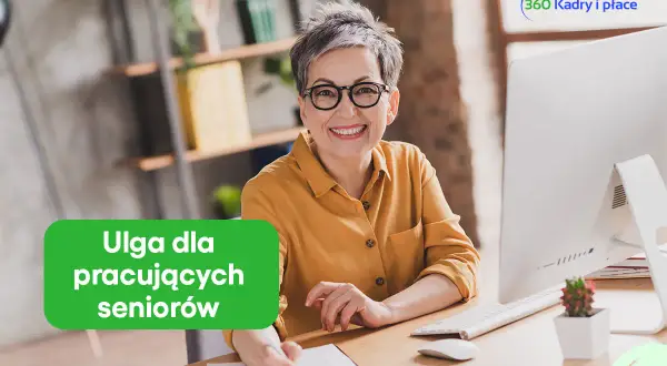 Uśmiechnięta kobieta w okularach przy biurku. Zielony napis "Ulga dla pracujących seniorów" informuje o korzyściach.