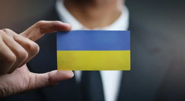 Dłoń trzyma kartkę z flagą Ukrainy. Sytuacja jest taka, jaka jest, ale nadzieja pozostaje.