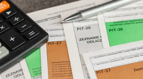 Kalkulator i długopis na dokumentach PIT-37, PIT-28, PIT-36. Zastanawiasz się, ile zwrotu z ulgi rehabilitacyjnej 2280? Czas na rozliczenie!