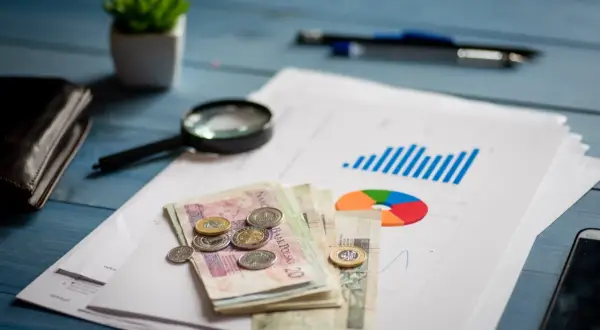 Analiza finansowa, pieniądze, lupa i wykresy na biurku. Planowanie restrukturyzacji kredytu.