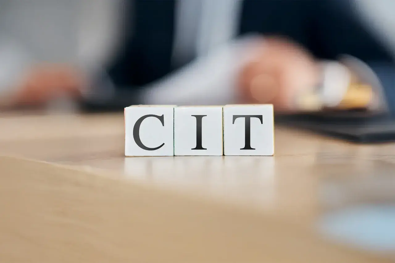 Trzy kostki z literami C, I, T. Symbolizują podatek CIT, który jest ważnym elementem finansów firm.