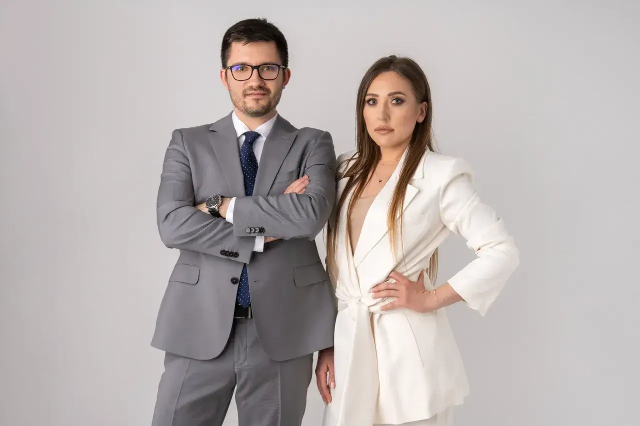 Para prawników w garniturach na jasnym tle.
