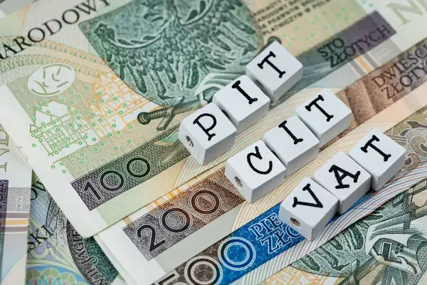 Polskie banknoty z napisami PIT i VAT. Ulga na złe długi może pomóc w rozliczeniu podatków.