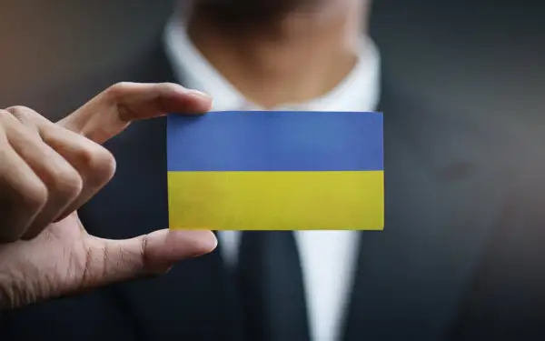 Dłoń trzyma kartkę z flagą Ukrainy. Sytuacja jest taka, jaka jest, ale nadzieja pozostaje.