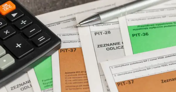 Kalkulator i długopis na dokumentach PIT-37, PIT-28, PIT-36. Zastanawiasz się, ile zwrotu z ulgi rehabilitacyjnej 2280? Czas na rozliczenie!