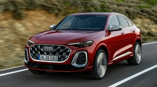 Czerwony Audi Q8 Sportback sunie po drodze, idealny do leasingu finansowego.
